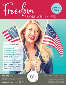 blonde woman smiling and holding two small American flags